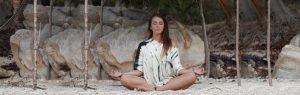 Woman on the beach meditating