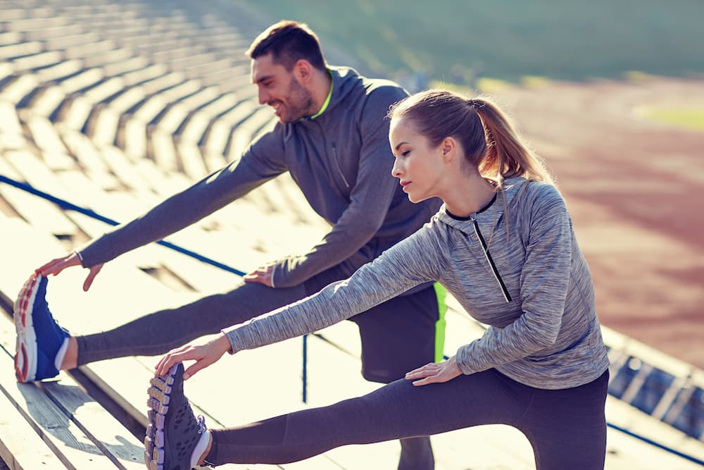 9 habits of healthy people. 1 man and 1 woman stretching after working out.